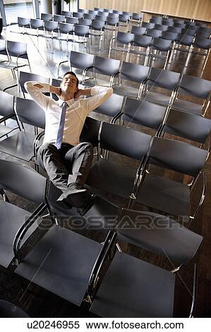 Stock Photography - Businessman relaxing in empty conference. Fotosearch
