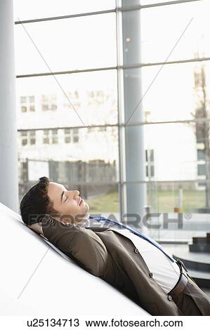 Businessman relaxing in office View Large Photo Image Stock Image - Businessman relaxing in office. Fotosearch