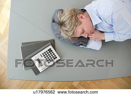 Stock Image - Businessman sleeping on conference table. Fotosearch