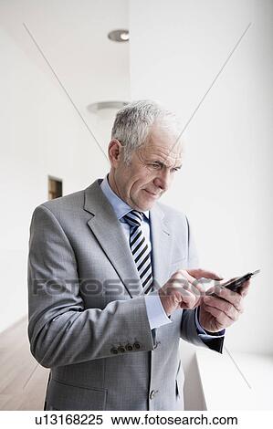 Stock Photography - Businessman typing on Handheld. Fotosearch