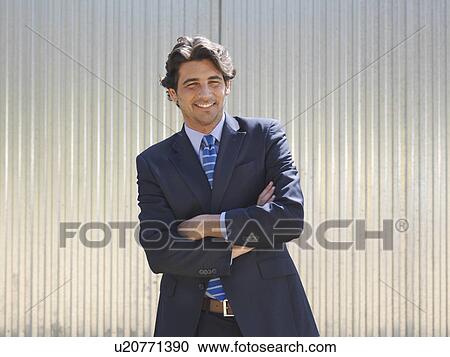 Stock Image - Businessman with folded arms smiling. Fotosearch