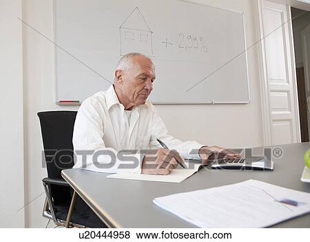 Businessman working on papers View Large Photo Image Stock Photo - Businessman working on papers. Fotosearch