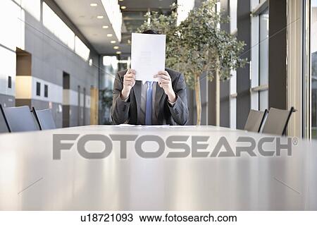 Stock Image - Businessmen holding paper work in front. Fotosearch