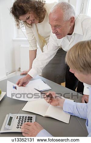 Businesspeople discussing papers View Large Photo Image Stock Image - Businesspeople discussing papers. Fotosearch