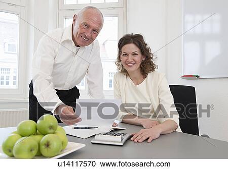Businesspeople discussing papers View Large Photo Image Stock Image - Businesspeople discussing papers. Fotosearch