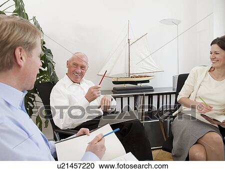 Businesspeople discussing papers View Large Photo Image Stock Image - Businesspeople discussing papers. Fotosearch
