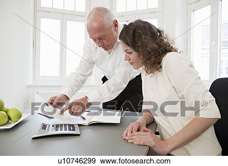 Businesspeople discussing papers View Large Photo Image Stock Photo - Businesspeople discussing papers. Fotosearch