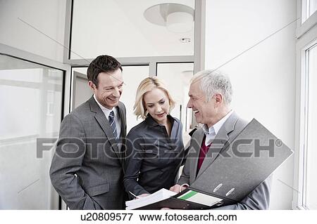 Stock Photo - Businesspeople looking at folder. Fotosearch