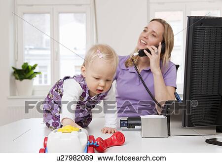 Stock Photo - Businesswoman and baby in office. Fotosearch