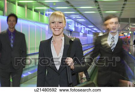 Stock Image - businesswoman at airport, happy. Fotosearch