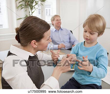 Businesswoman, boy playing string game View Large Photo Image Stock Photography - Businesswoman, boy playing string game. Fotosearch