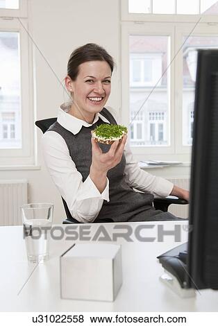 Businesswoman eating healthy snack View Large Photo Image Stock Photo - Businesswoman eating healthy snack. Fotosearch