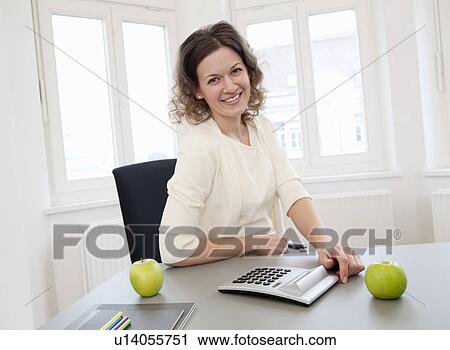 Stock Image - Businesswoman in office. Fotosearch