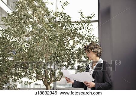 Businesswoman looking at paperwork View Large Photo Image Stock Photograph - Businesswoman looking at paperwork. Fotosearch