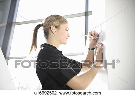 Stock Image - Businesswoman signing document. Fotosearch