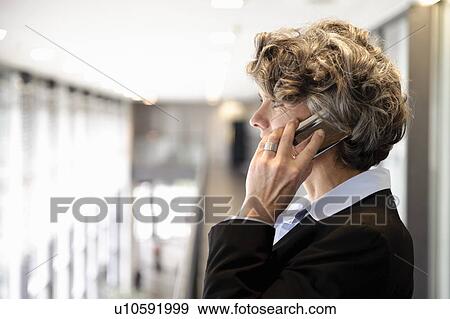 Stock Photo - Businesswoman using cell phone. Fotosearch