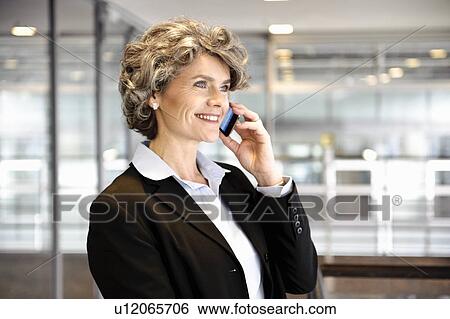 Businesswoman using cell phone View Large Photo Image Stock Photograph - Businesswoman using cell phone. Fotosearch