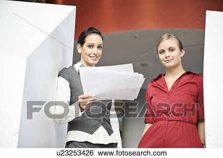 Stock Photograph - Businesswomen looking at paperwork. Fotosearch