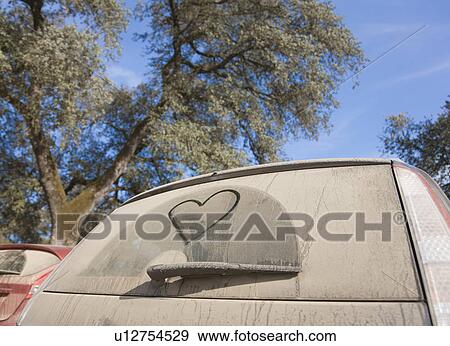 Stock Photo - Car with heart shape drawn in dirt. Fotosearch