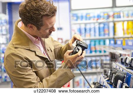 Stock Photo - Checking a reflex cameras' features. Fotosearch