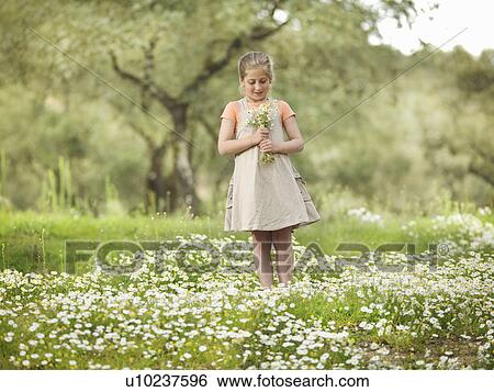 Stock Photograph - Child holding a bunch of daisies. Fotosearch