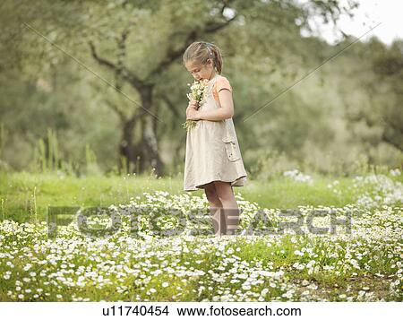 Picture - Child smelling bunch of daisies. Fotosearch