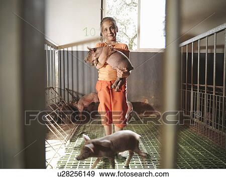 Child standing in pen holding a piglet View Large Photo Image Stock Photo - Child standing in pen holding a piglet. Fotosearch
