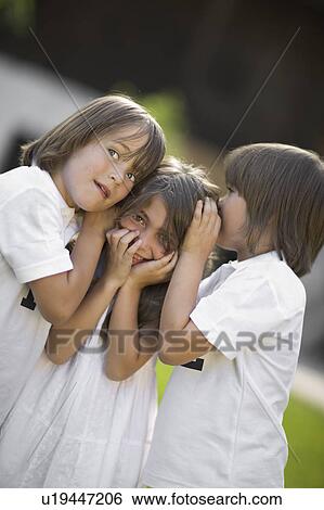 Stock Photograph - Children having a secret. Fotosearch