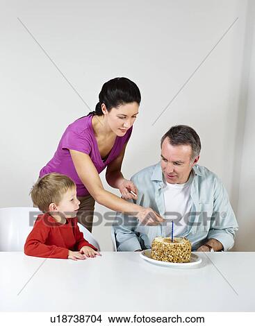 Couple and young son with birthday cake View Large Photo Image Picture - Couple and young son with birthday cake. Fotosearch
