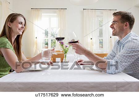Stock Photo - Couple at restaurant toasting with wine. Fotosearch