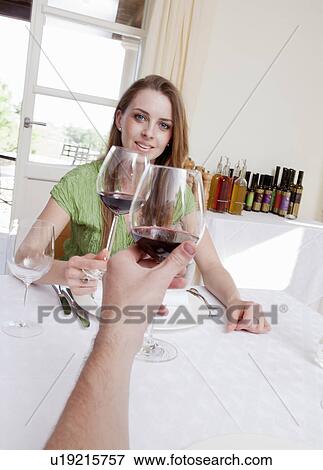 Stock Photo - Couple at restaurant toasting with wine. Fotosearch