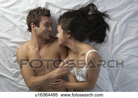 Couple in bed laughing, high angle View Large Photo Image Stock Photography - Couple in bed laughing, high angle. Fotosearch