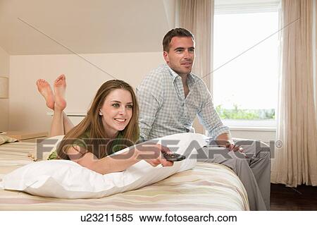 Couple in hotel room watching TV View Large Photo Image Stock Photography - Couple in hotel room watching TV. Fotosearch