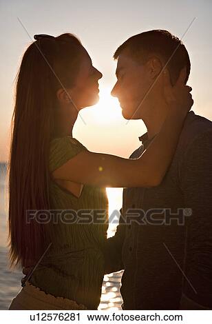 Couple kissing at beach View Large Photo Image Stock Image - Couple kissing at beach. Fotosearch