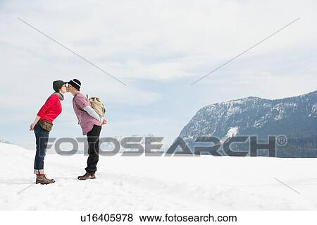 Stock Photo - Couple kissing in front Alps. Fotosearch