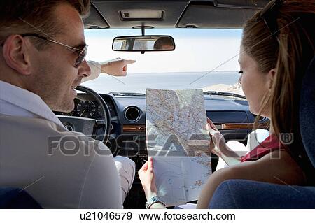 Couple looking at map in car by sea View Large Photo Image Stock Photo - Couple looking at map in car by sea. Fotosearch