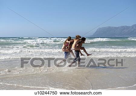 Stock Image - Couple piggyback racing. Fotosearch