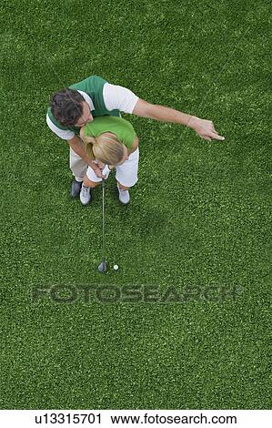 Stock Image - Couple playing golf. Fotosearch