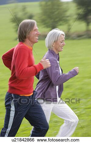 Stock Photograph - Couple running in field. Fotosearch