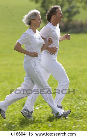 Couple running in field View Large Photo Image Stock Photography - Couple running in field. Fotosearch