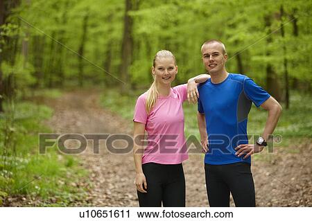 Stock Image - Couple running in forest, standing still. Fotosearch