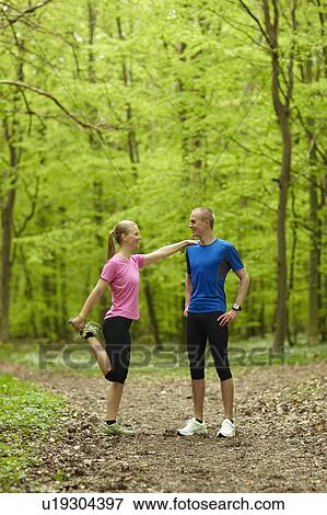 Couple running in forest, stretching View Large Photo Image Stock Photo - Couple running in forest, stretching. Fotosearch