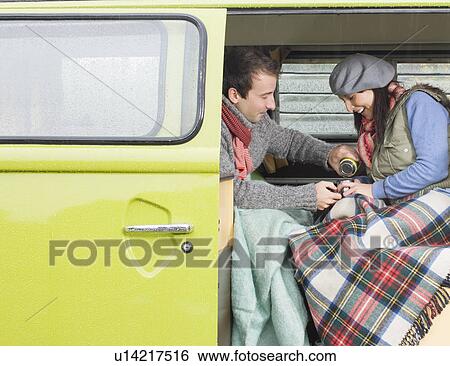 Stock Photograph - Couple sharing a hot drink together. Fotosearch
