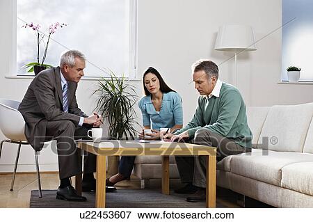 Stock Photo - Couple signing papers with adviser. Fotosearch