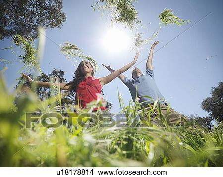 Couple throwing grass in the air View Large Photo Image Picture - Couple throwing grass in the air. Fotosearch