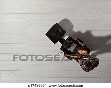 Picture - Couple using laptop together on chair. Fotosearch