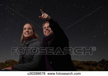 Stock Photo - couple watching the starry night sky. Fotosearch