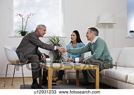 Stock Image - Couple with financial adviser. Fotosearch