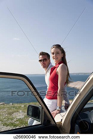 Couple with oldtimer by sea View Large Photo Image Stock Photograph - Couple with oldtimer by sea. Fotosearch