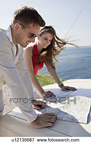 Couple with oldtimer looking at map View Large Photo Image Stock Photo - Couple with oldtimer looking at map. Fotosearch